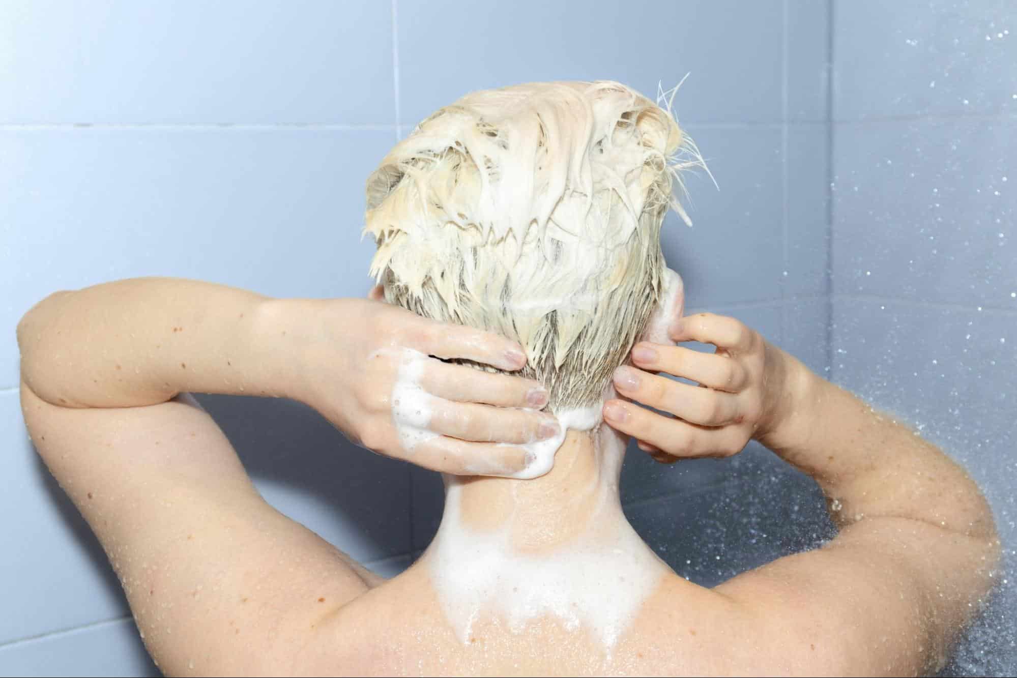 A man washing his behind ears.
