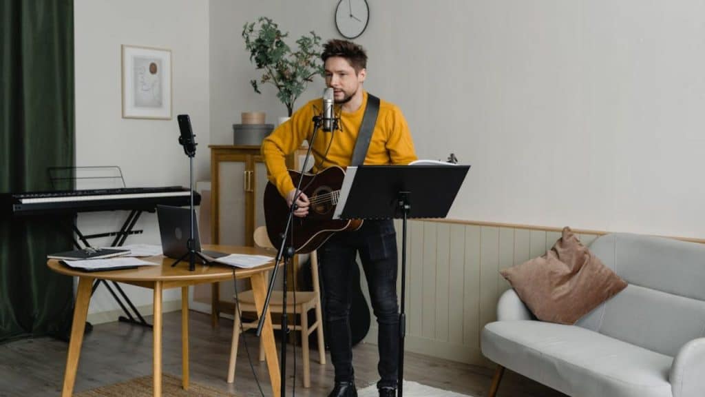 Man playing the guitar while singing reflects personal passion