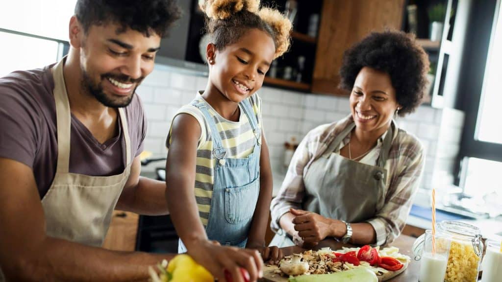 A family cooking together in a kitchen.
