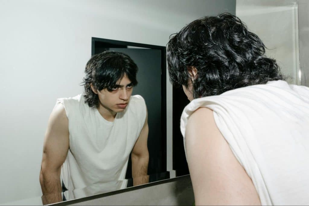 A man looking at the mirror.