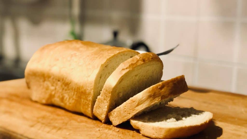 A sliced loaf of bread on a wooden cutting board.