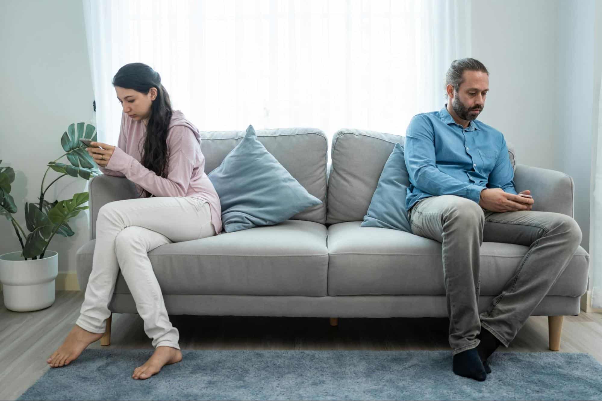 A man and woman sitting away from each other.
