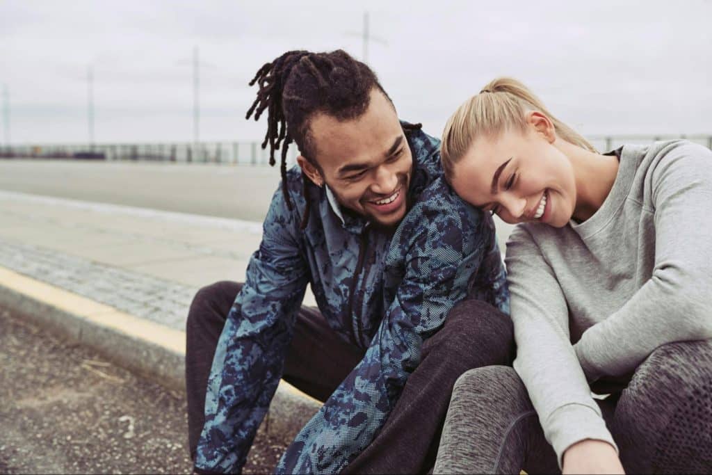 A man and woman sitting at the pavements