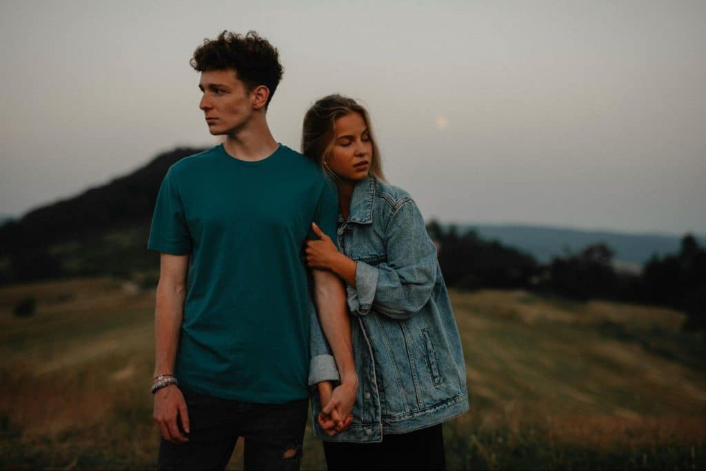 A woman holding a man’s arm.