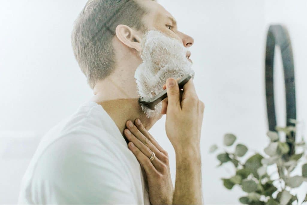 A man shaving his beard.