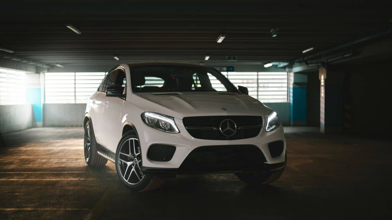 A white Mercedes-Benz SUV with black accents is parked indoors.