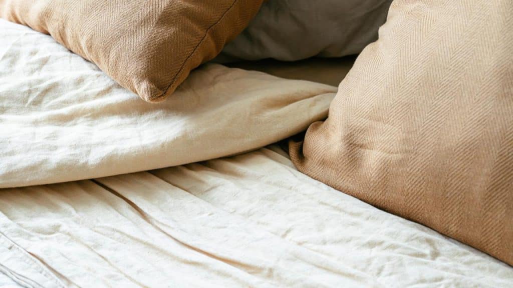 A close-up of beige pillows on a bed.