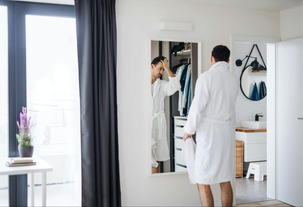 A man looking at the mirror.