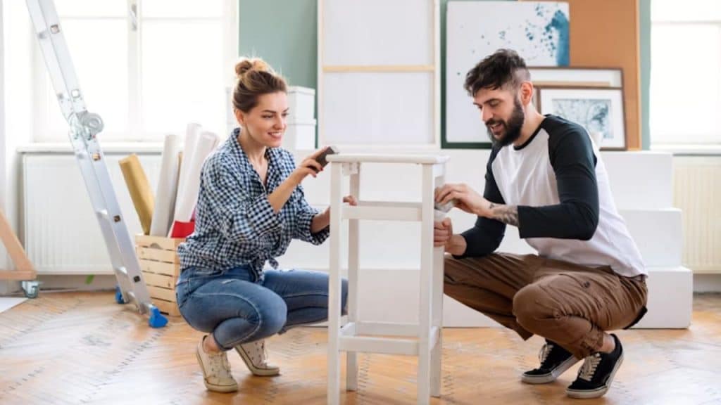Couple building a bookshelf together in their living room.