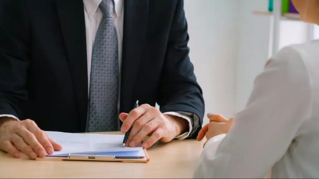 A professional reviewing documents across a desk.