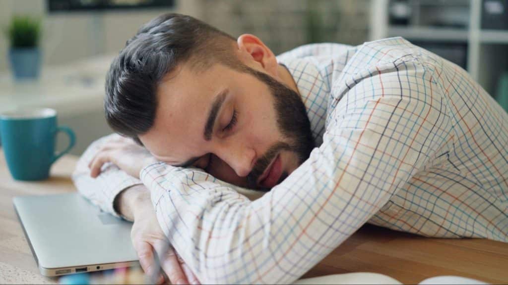 A man sleeping on his laptop