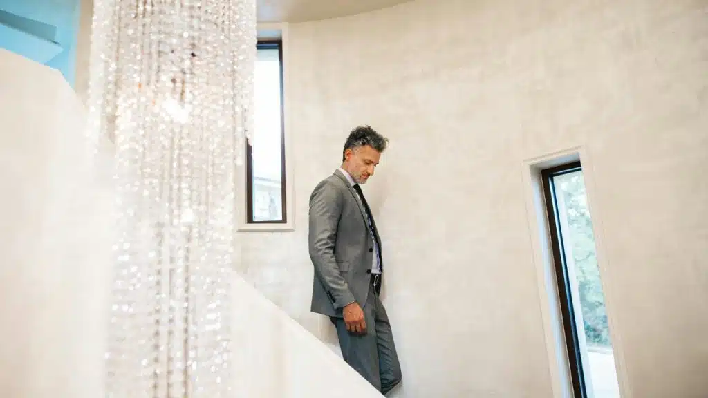 A man in a suit descending a staircase.