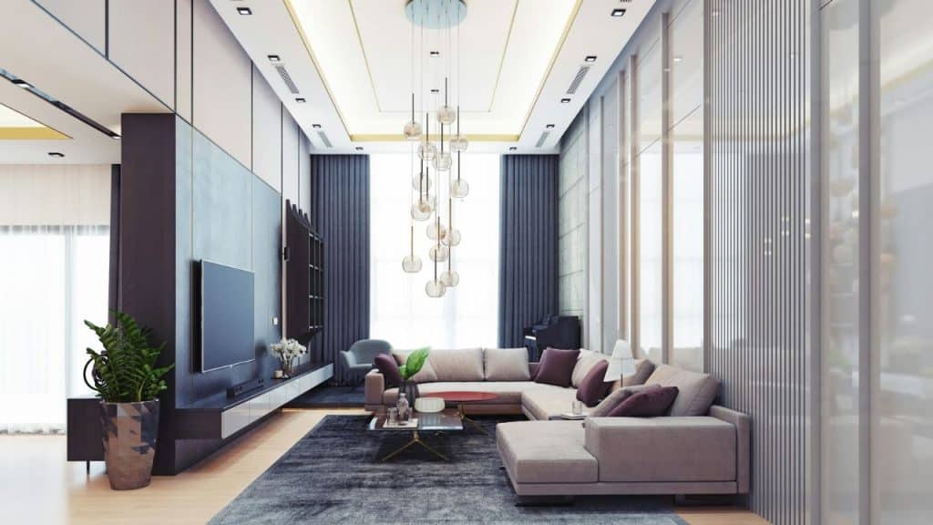 A luxurious modern living room with a large sectional sofa, TV, and unique chandelier.