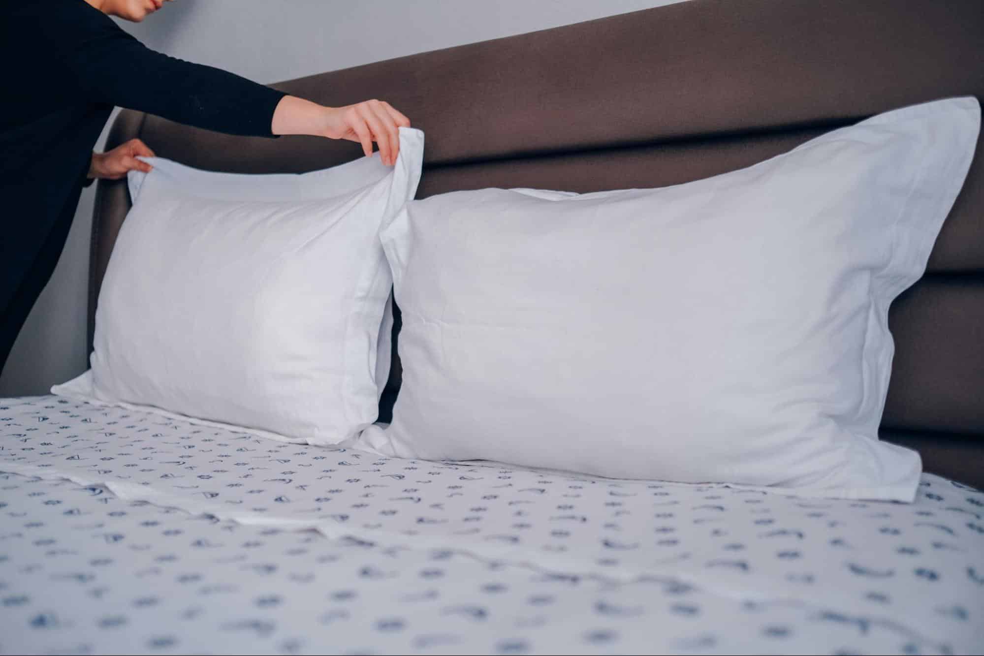 A person changing pillowcases.