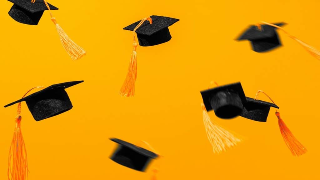 Graduation caps flying in the air