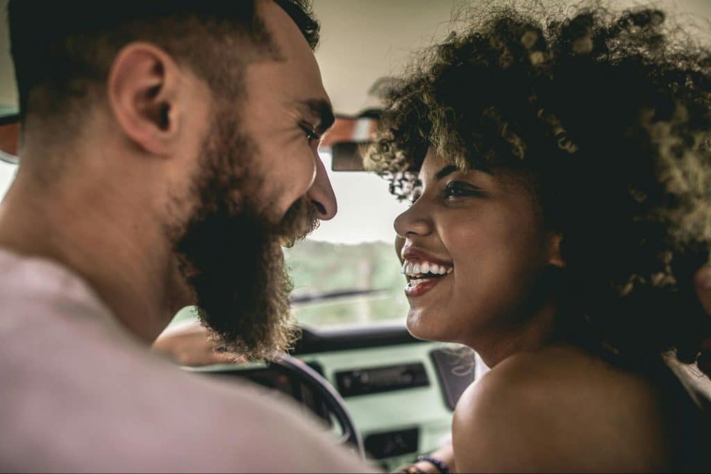 A man and woman facing each other while being happy