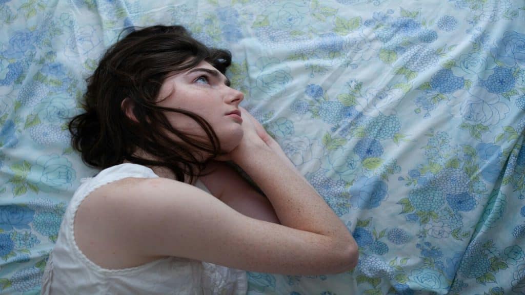 A woman looking worried in bed