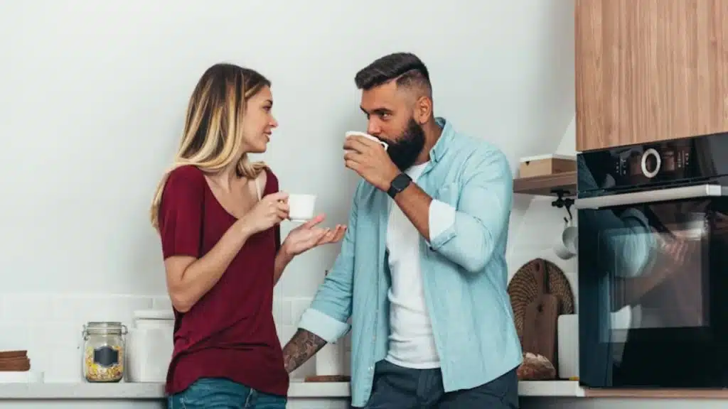 Man and woman discussing their financial upbringings over coffee.
