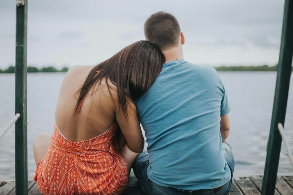 A man and woman sitting on the dock