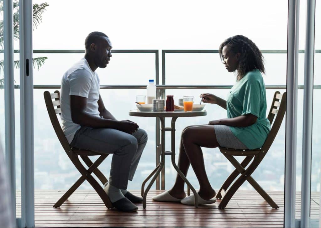 A man and woman eating at the balcony