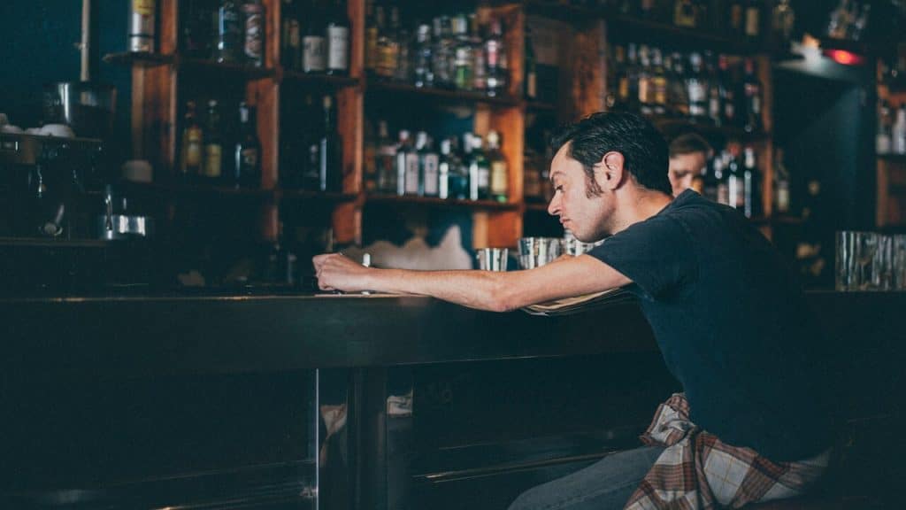 A man looking wistful at a bar