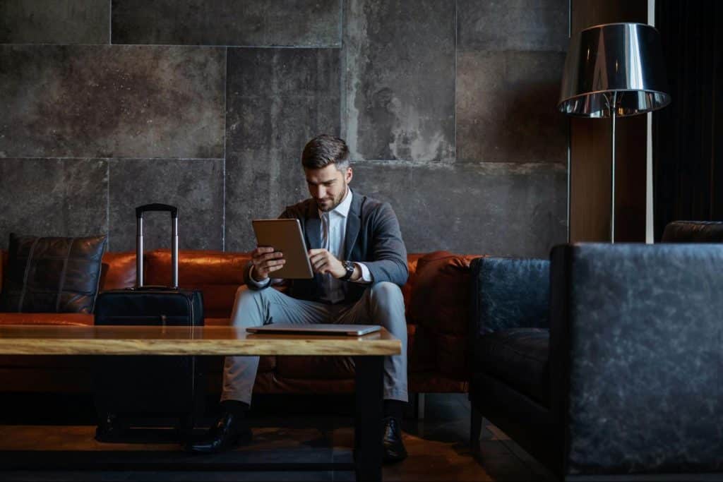 A man looking rich and sitting alone at the couch.