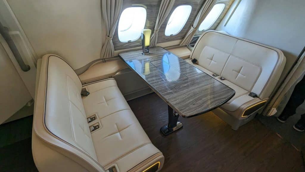 A private jet cabin seating area with opposing leather benches and a central table.