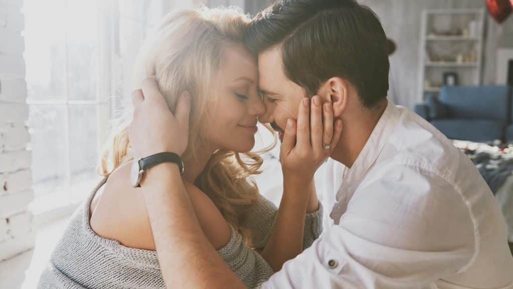 A couple touching foreheads affectionately.