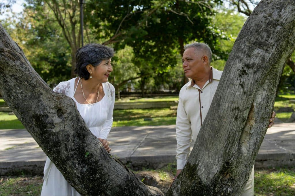 A man and woman having a picture together on the tree.