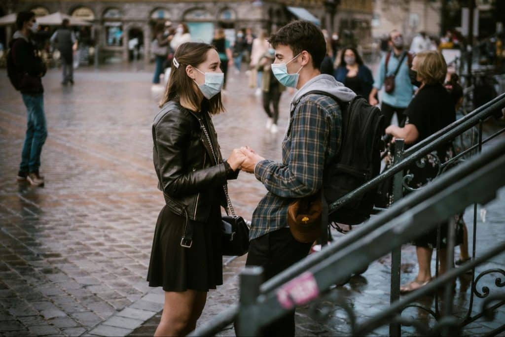 A man and woman facing each other and holding hands.