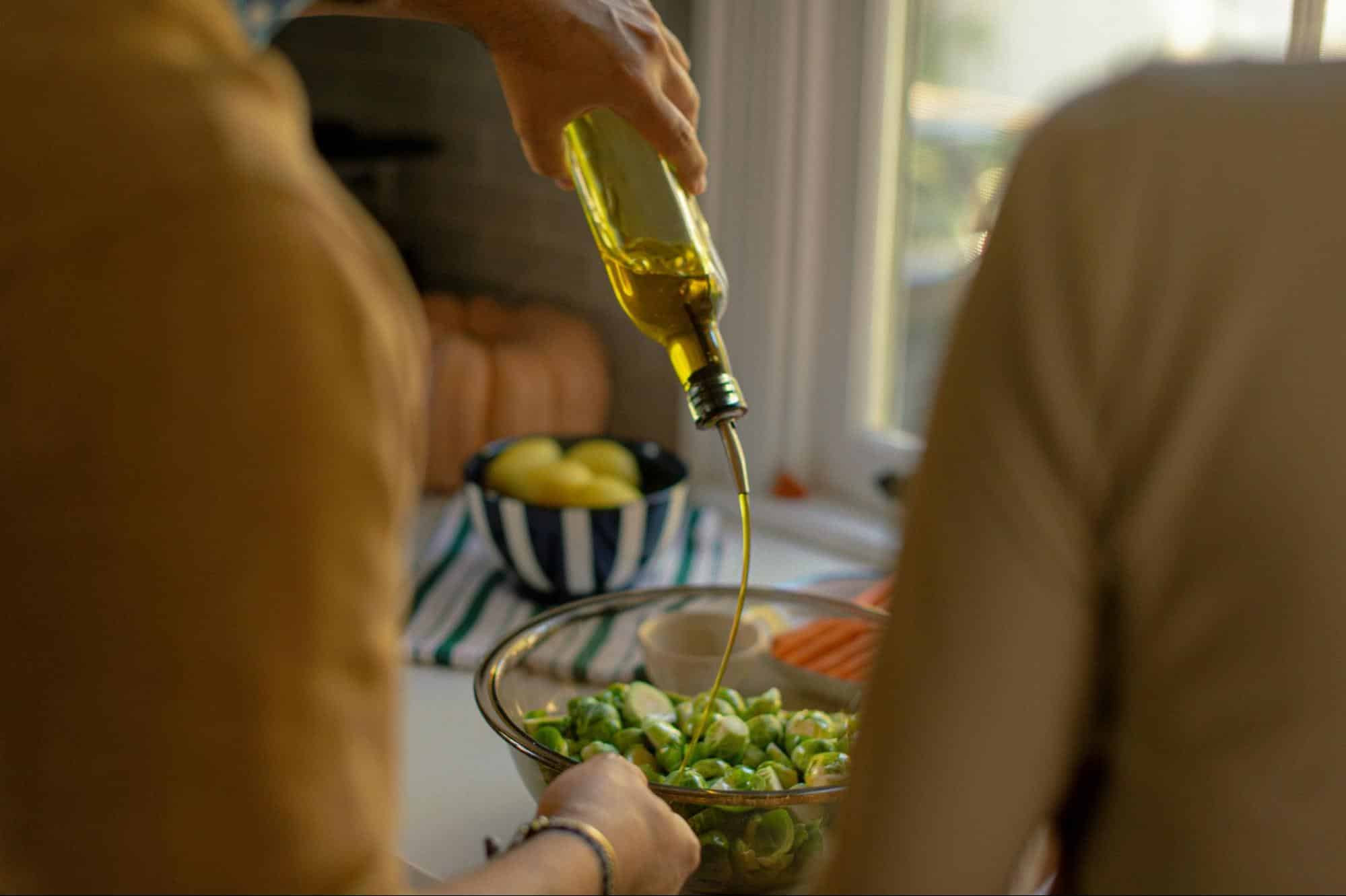 A picture of a man pouring olive oil.