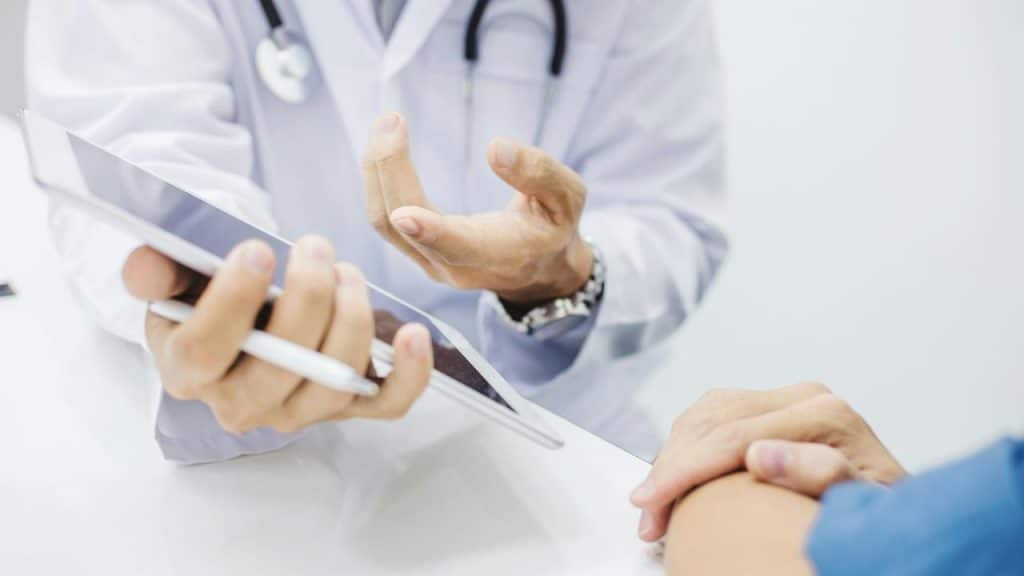 A doctor showing a tablet to a patient.