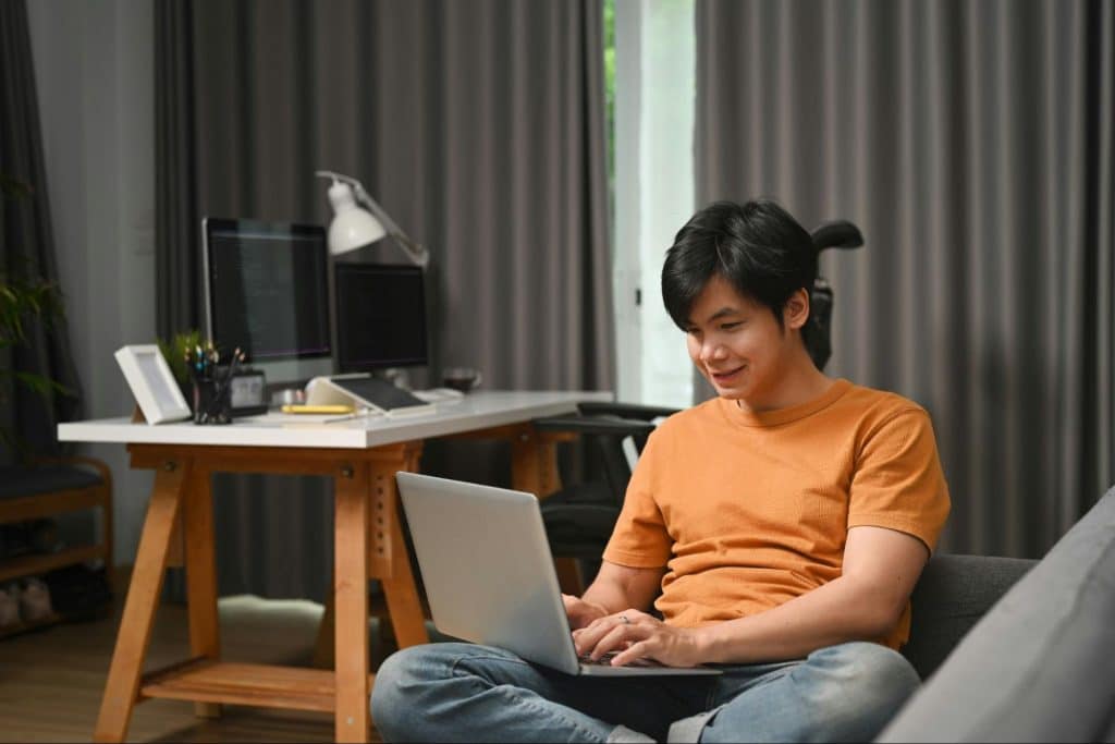 A man typing something on his laptop.
