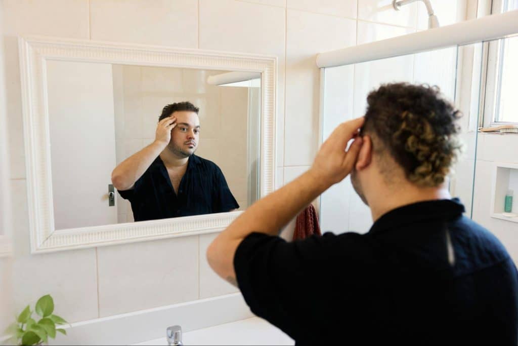 A man checking his hair.