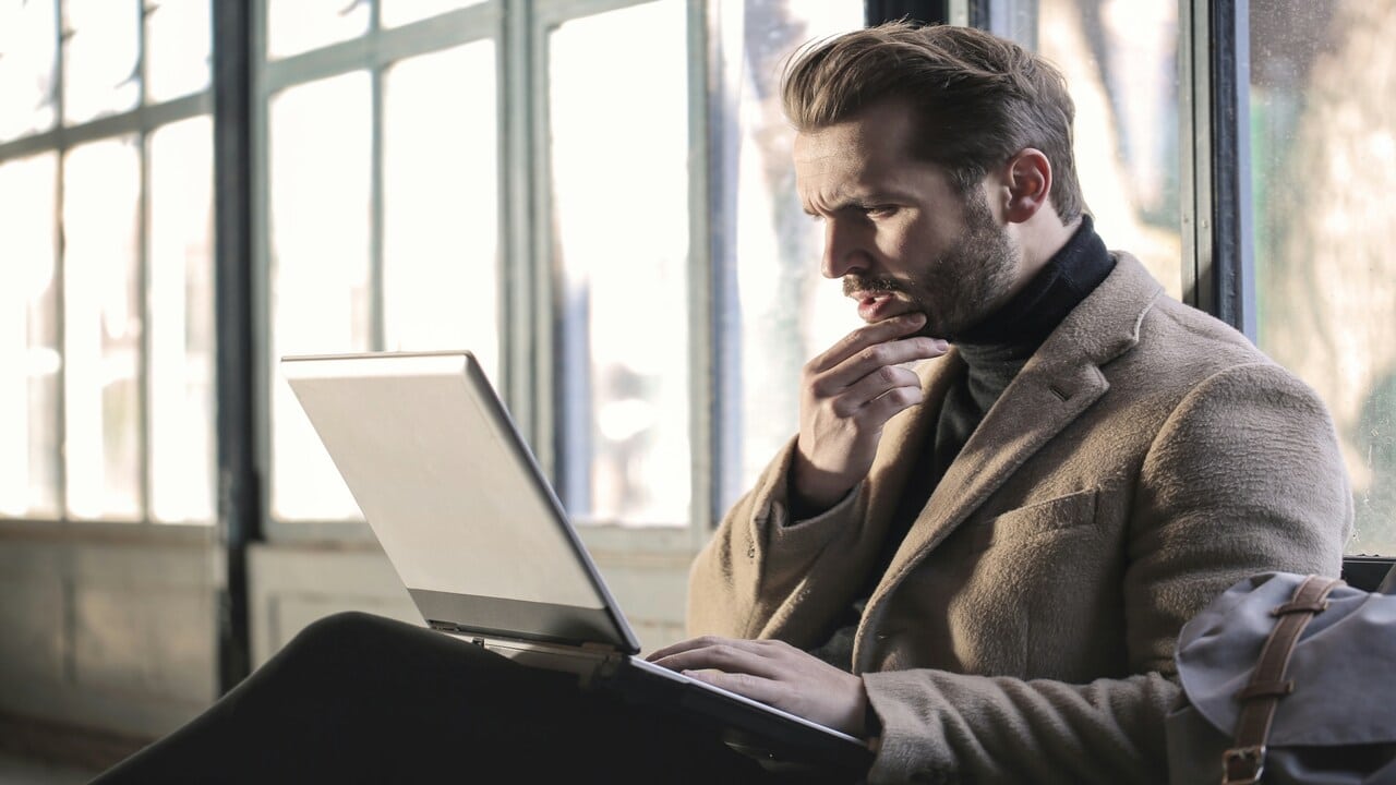 A man thinking in front of his laptop.