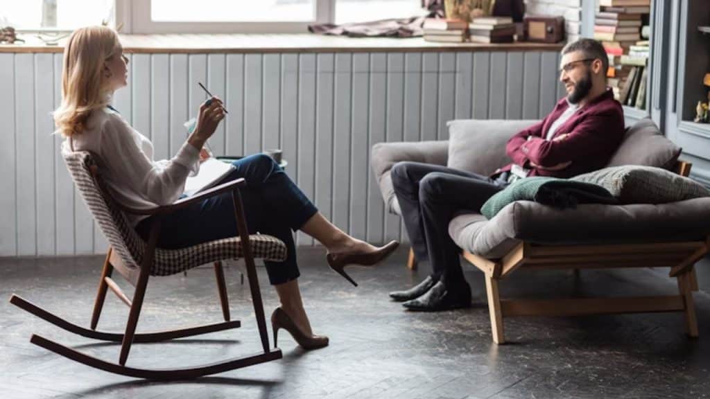 Man speaking to a therapist in a warm, calming space.