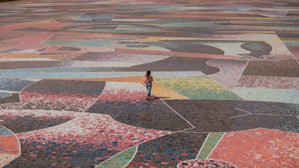 A woman walking on the tiled floor.