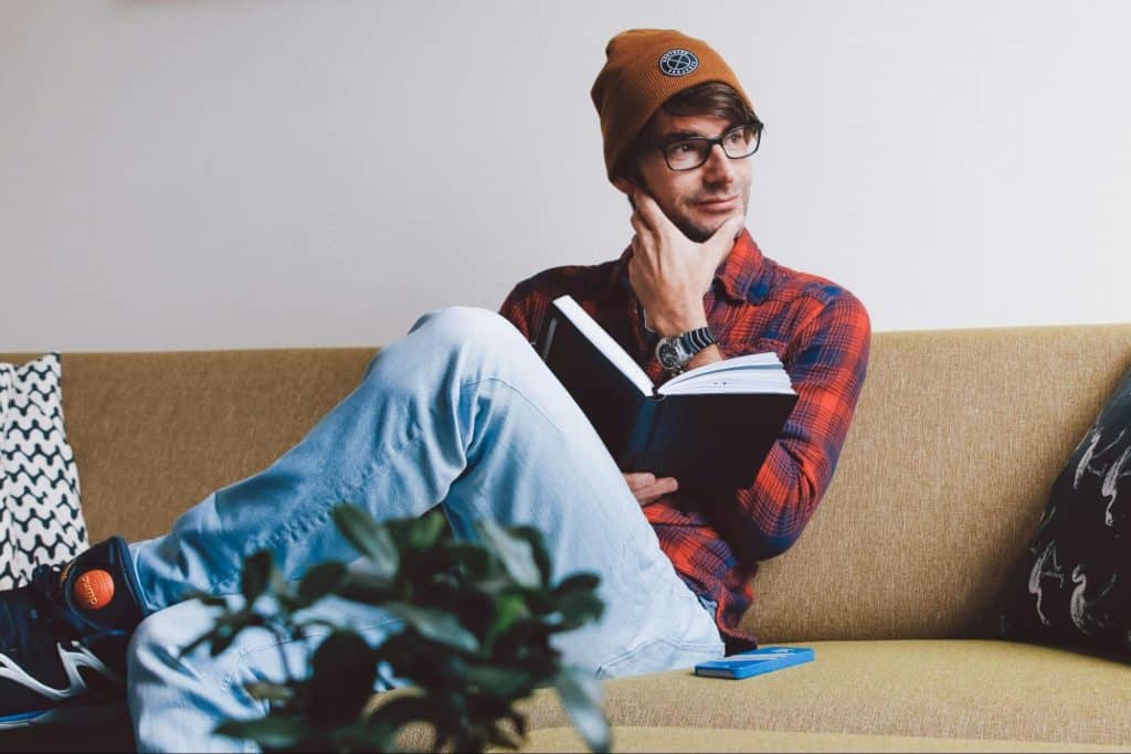 A man holding a book while thinking.