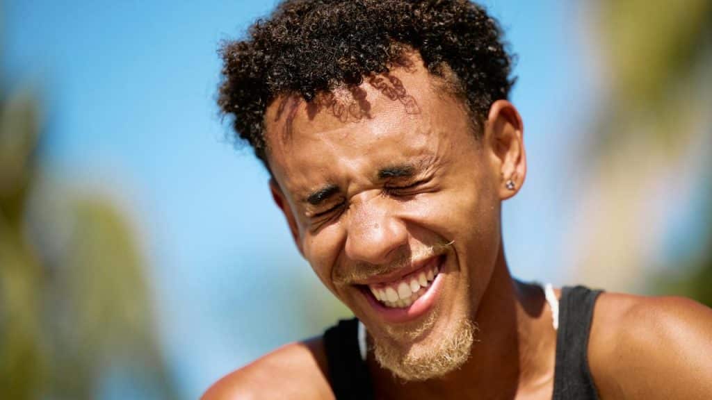 A man laughing with his eyes closed.