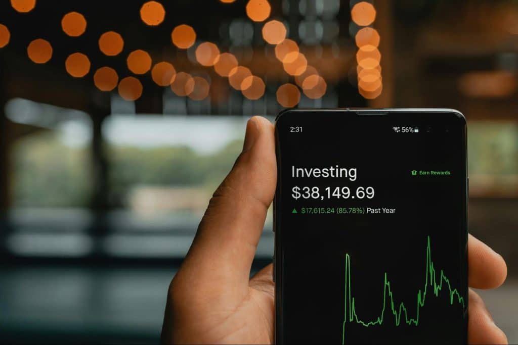 A picture of a person holding a phone that says investing on it