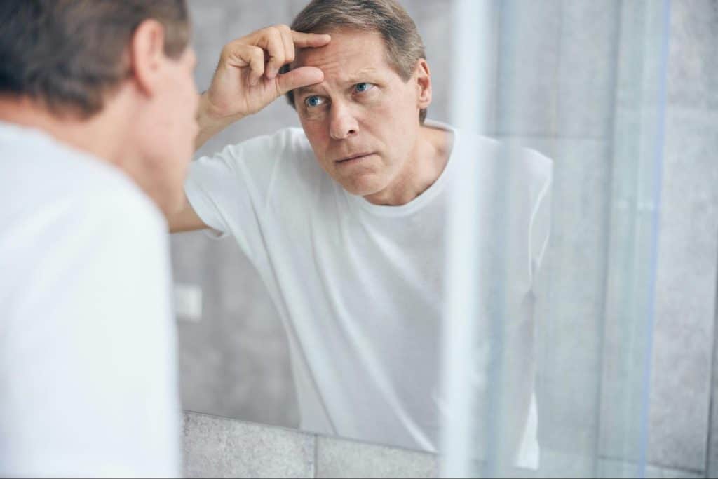 A man pinching his forehead.