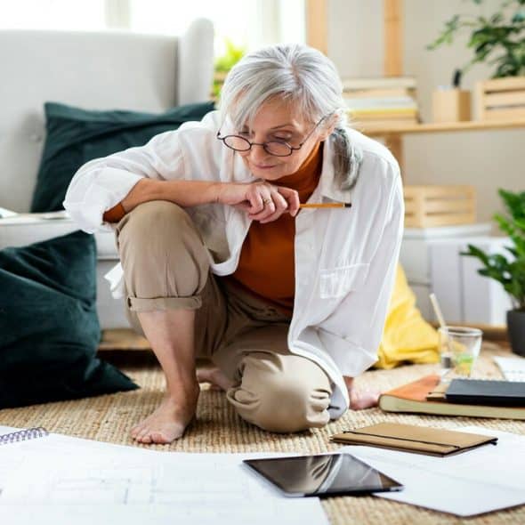 An older woman looking at blueprints