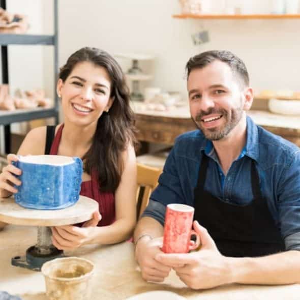Couple bonding over a shared pottery hobby in a relaxed creative space.