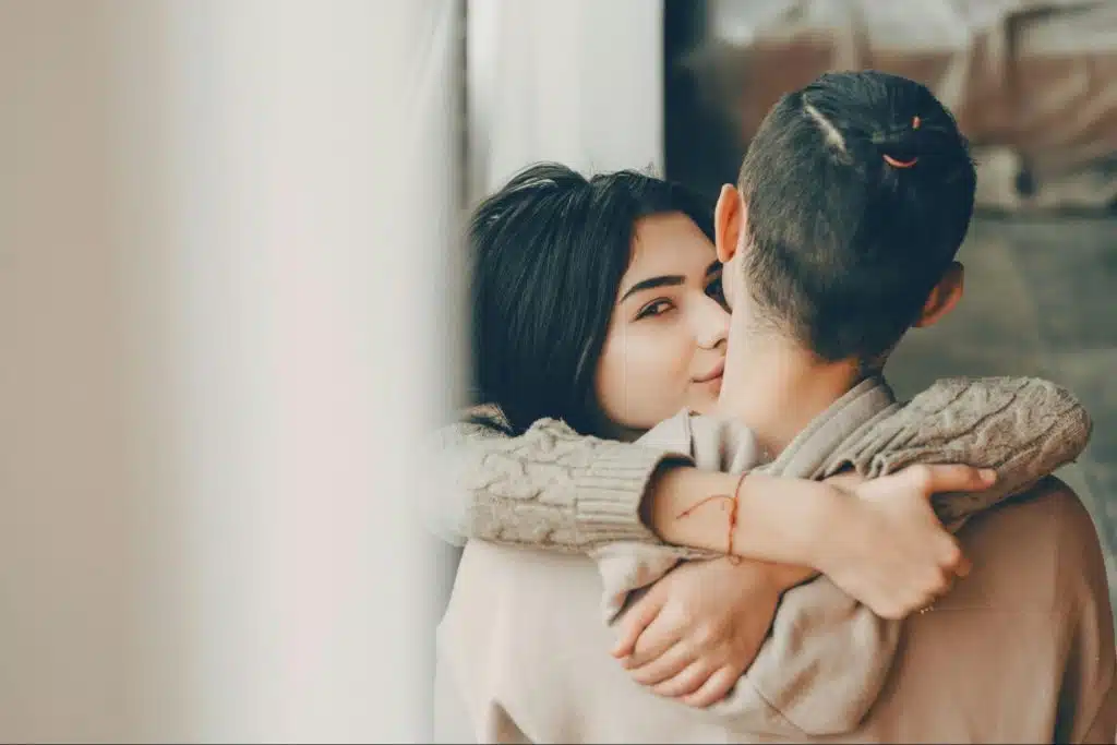 A woman kissing a manβs cheek