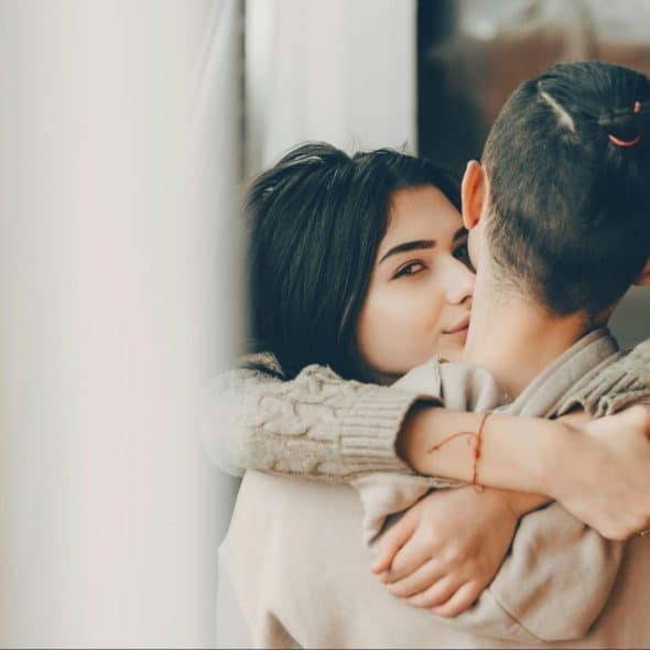 A woman kissing a man’s cheek