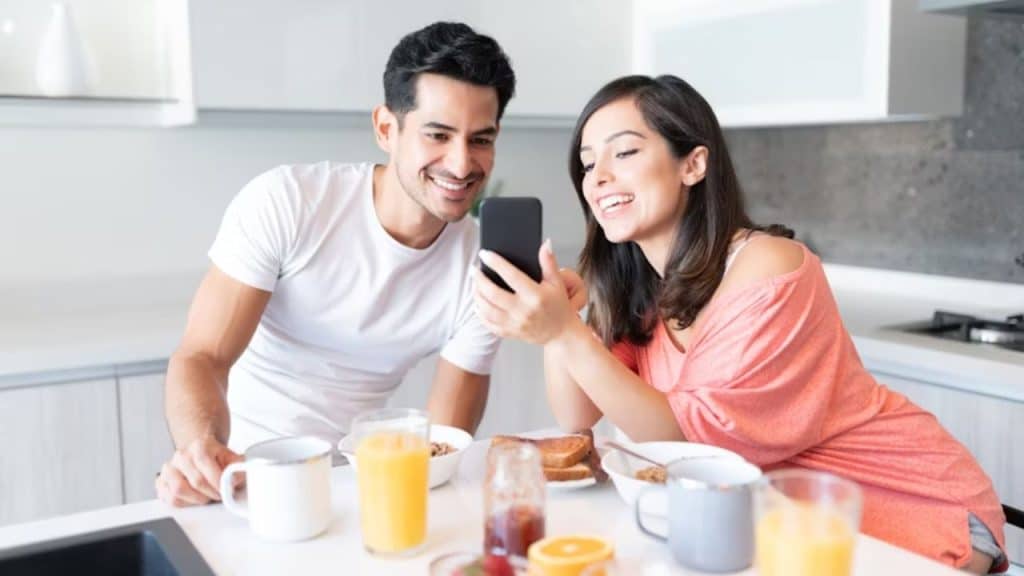 Man and wife conducting a casual financial review over breakfast.