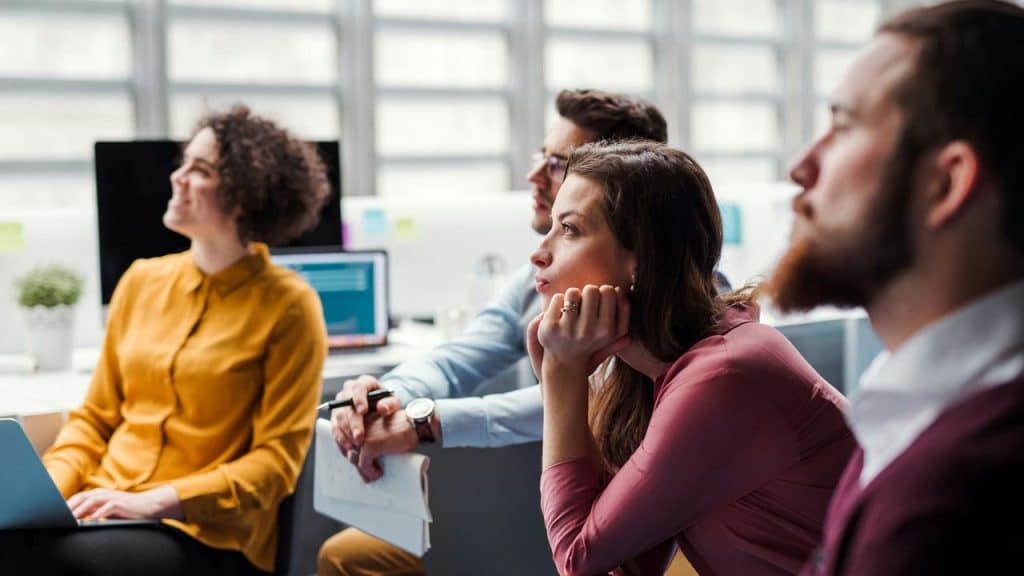 A group of professionals attentively listening to a presentation.