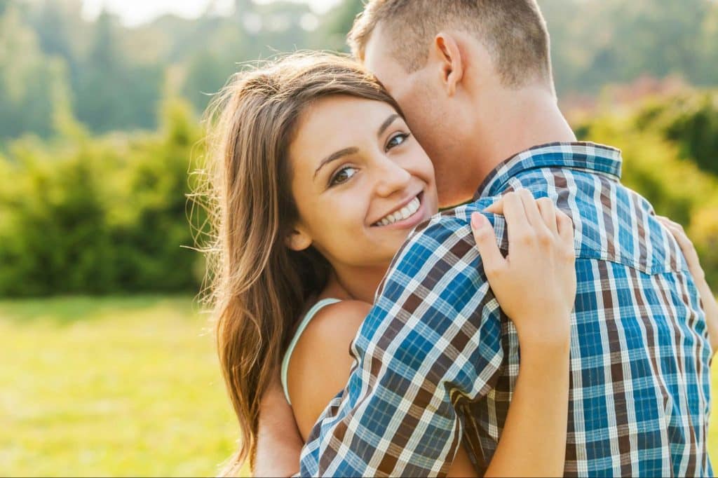 A man hugging a happy woman.