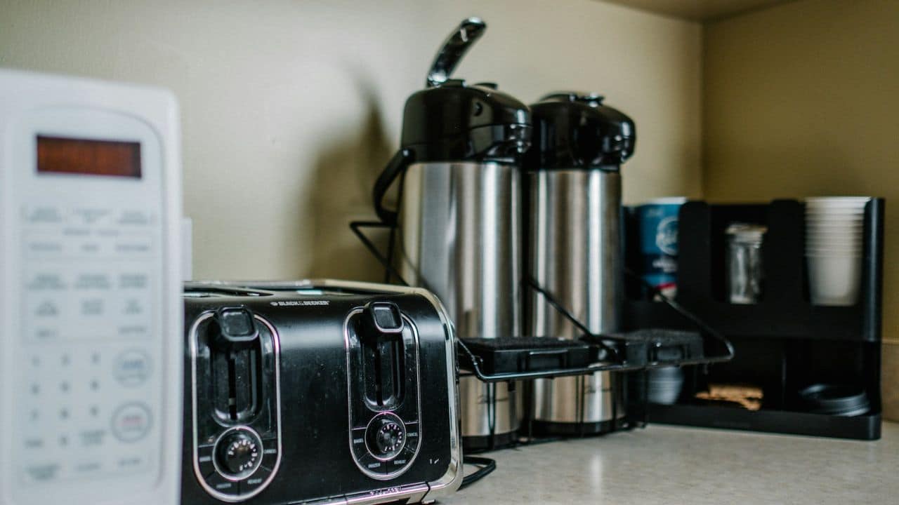 A toaster, coffee dispensers, and a beverage station on a kitchen counter.