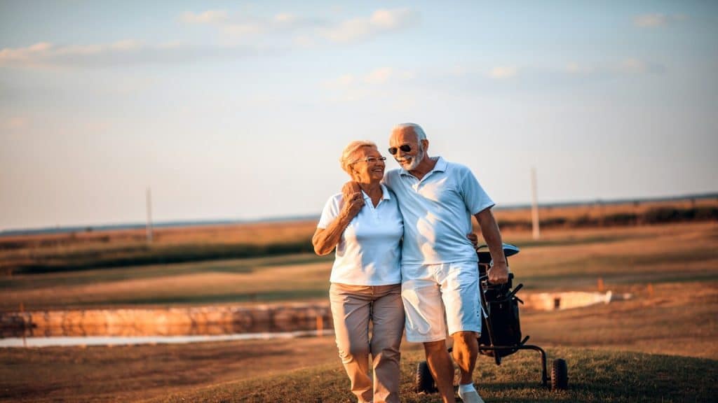 An older couple golfing together